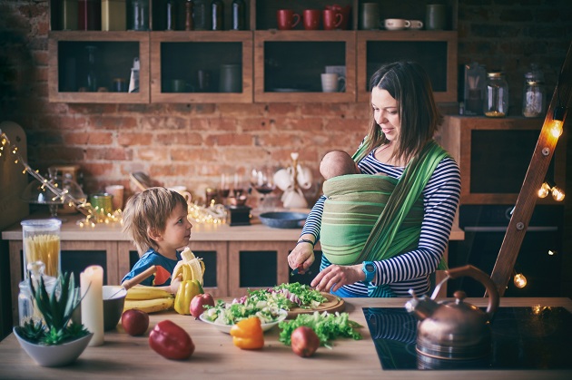 mama-care-se-afla-in-bucatarie-cu-un-bebelus-in-ham-si-cu-fiul-mai-mare-si-vrea-sa-si-aleaga-fructe-si-legume-pentru-a-gati