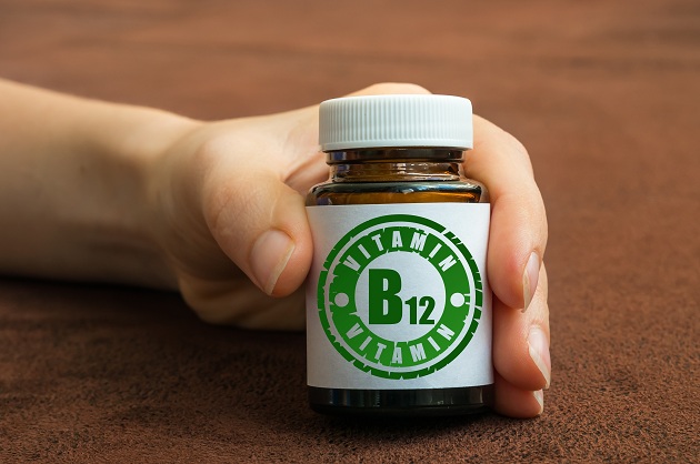 mana-de-femeie-care-tine-un-recipient-de-vitamina-B12