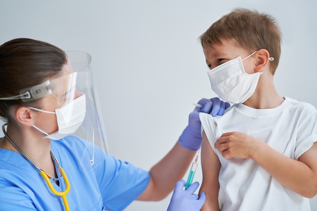 cadru-medical-cu-viziera-si-masca-care-vaccineaza-un-baietel