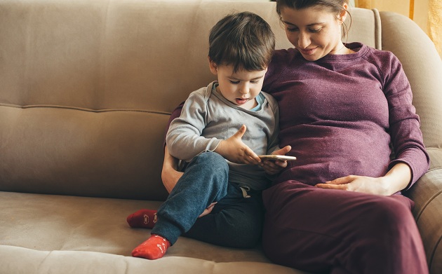 mama-care-sta-pe-canapea-langa-baietelul-ei-care-se-uita-pe-telefon