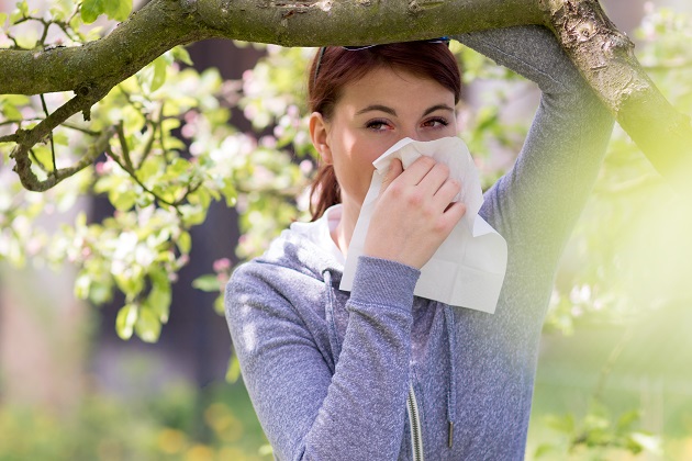 femeie-care-se-afla-sun-un-pom-inflorit-si-are-o-reactie-alergica