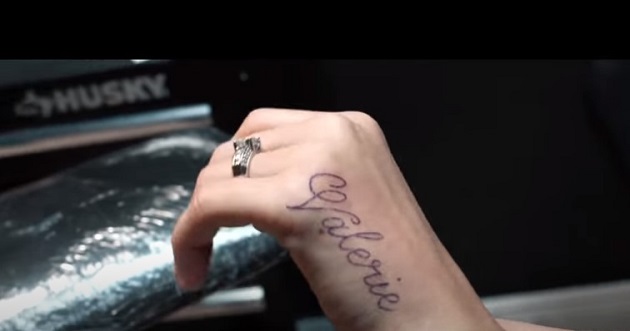mana-de-femeie-cu-inel-si-cu-un-tatuaj-cu-nume-scris-cu-litere-de-mana