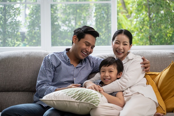 familie-asiatica-formata-din-mama-tata-si-copil-toti-trei-stand-fericiti-pe-canapea