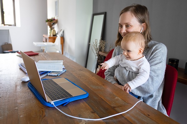 mama-zambitoare-ce-sta-la-birou-tinandu-si-fetita-in-brate-si-comunicand-cu-ajutorul-laptop-ului