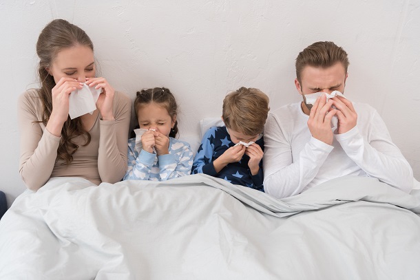 mama-tata-si-cei-doi-copii-stand-in-pat-si-suflandu-si-nasul-din-cauza-unei-raceli-sau-a-unei-gripe