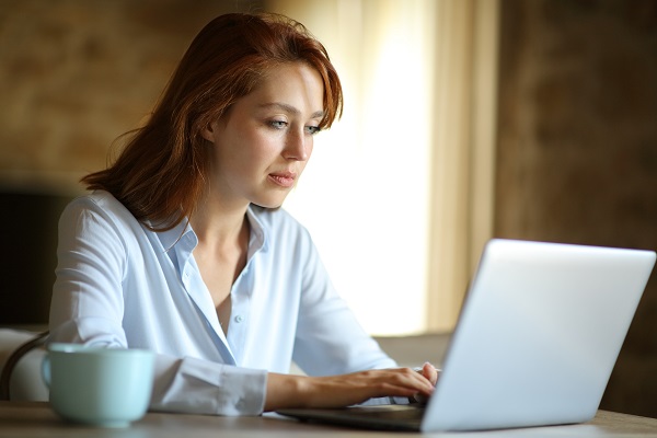 femeie-tânără-cu-parul-roscat-care-lucreaza-cu-laptop-ul