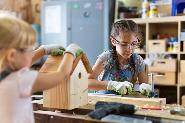 fetite-care-lucreaza-intr-un-atelier-de-prelucrare-a-lemnului-pentru-a-construi-o-casuta-pentru-pasari