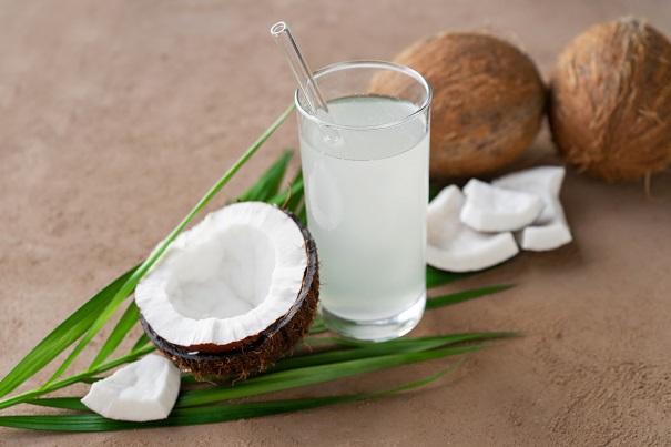 nuca-de-cocos-frunza-de-palmier-si-pahar-cu-pai-in-care-afla-apa-de-cocos