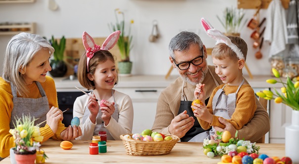 copii-veseli-purtand-urechi-de-iepurasi-bucurosi-ca-picteaza-oua-de-Paste-alaturi-de-bunicii-lor