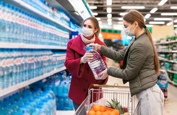 femei-tinere-purtand-masca-de-protectie-incercand-sa-achizitioneze-apa-de-la-supermarket