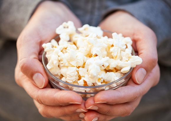 mâini-de-femeie-care-tin-un-castronel-in-care-se-afla-popcorn