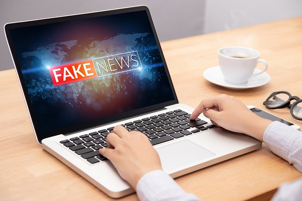 femeie-in-fata-laptop-ului-ilustrarea-conceptului-fake-news