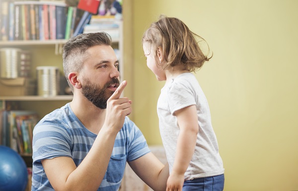 tata cu barba si mustata care îi explica ceva fetitei sale
