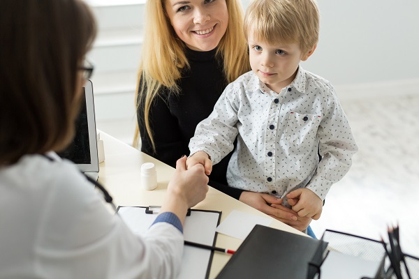 baietel care se afla cu masa la o consultatie la medic si face cunostinta cu acesta