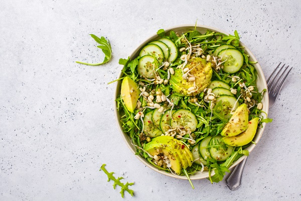 castron cu salata ce contine avocado, germeni de plante, castraveti si ruccola