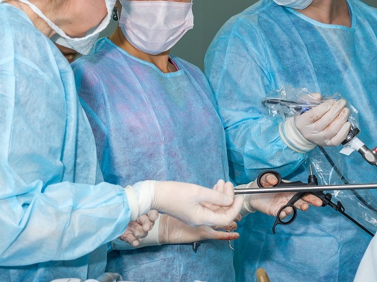 echipa de chirurgi care lucreaza cu instrumente speciale pentru o interventie laparoscopica