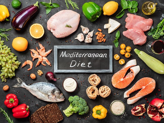 diverse alimente ce fac parte din dieta mediteraneeana si tablita pe care scrie denumirea acestei diete