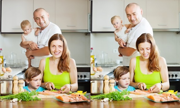 mama fericita care incearca sa pregateasca peste ca sa-l gateasca in bucatarie alaturi de partenerul ei si de cei doi copii ai lor