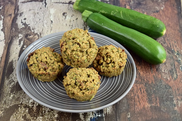 briose din faina integrala pe o farfurie, langa farfurie aflandu-se doi zucchini