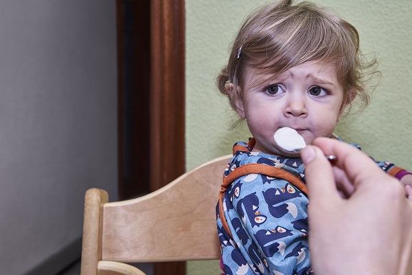 mama care incearca sa îi dea sa manance fetitei sale, care nu mai vrea