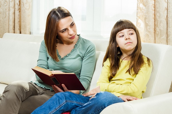 mama si fiica pe canapea, mama incearca sa-si convinga fata sa citeasca