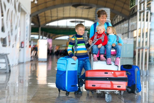 mama vesela alaturi de cei trei copii ai ei intr-un aeroport
