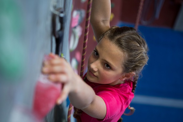 adolescenta ambitioasa care se urca pe un perete de escalada