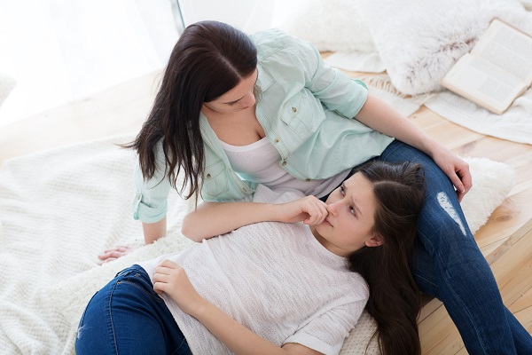 adolescenta ingrijorata stand cu capul in poala mamei sale