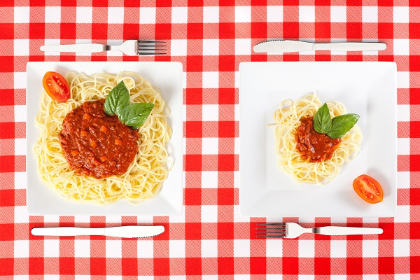 portie mare si portie mica de spaghete bolognese pe farfurii patrate albe
