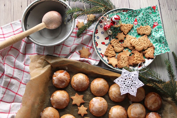 turta dulce in diverse forme de Craciun, pe o farfurie festiva si turta dulce rotunda intr-o tava