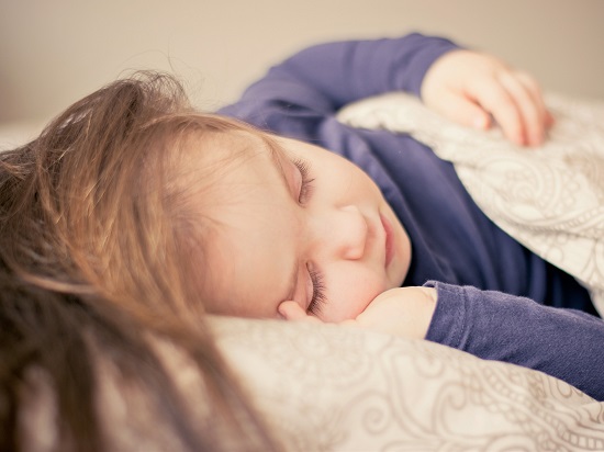 fetita in pijama cu maneca lunga dormind