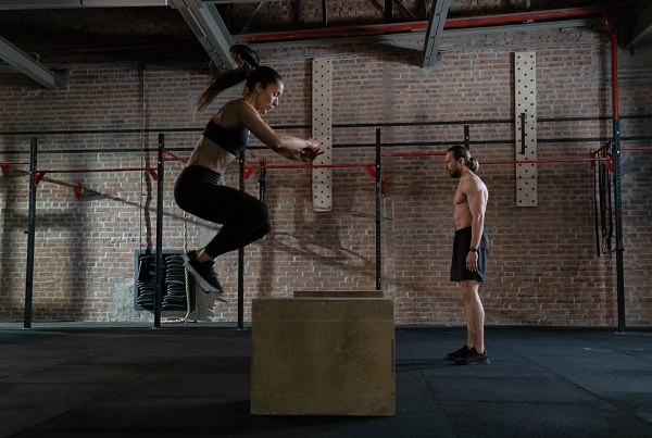 femeie si barbat in timpul unui antrenament plyometric in sala de sport