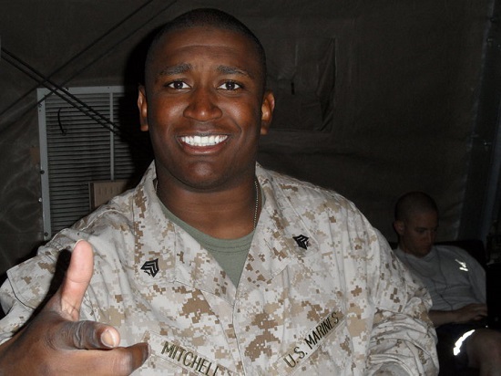 barbat de culoare vesel, in timp ce poarta uniforma specifica marinei SUA