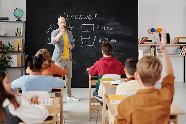 profesor la tabla incercand sa le ofere explicatii elevilor sai