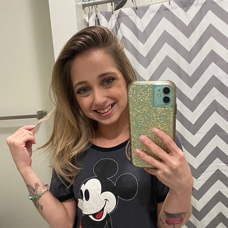 tanara cu tricou cu Mickey Mouse facandu-si selfie
