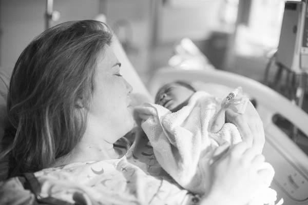 mama emotionata care isi tine in brate nou-nascutul imediat dupa nastere