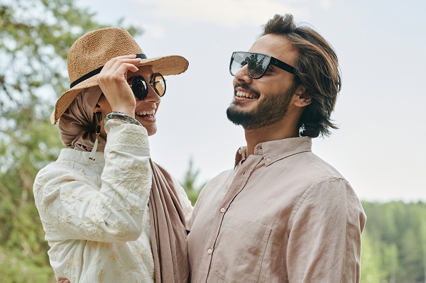 parteneri de cuplu purtand ochelari de soare si râzând impreuna