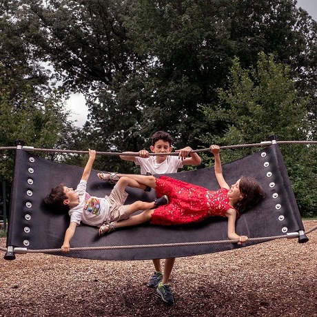 trei copii distrandu-se cu un hamac in aer liber