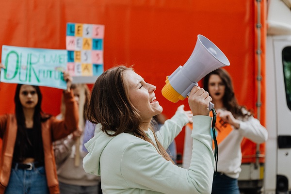 femeie care utilizeaza un megafon pentru a se face auzita la o manifestatie