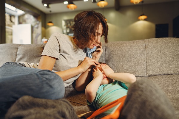 mama ingrijorata care vrea sa sune la medic intrucat baietelul ei se simte rau