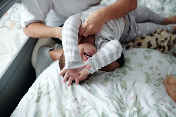 baietel in pijama care are un tantrum in pat, iar mama lui incearca sa-l calmeze