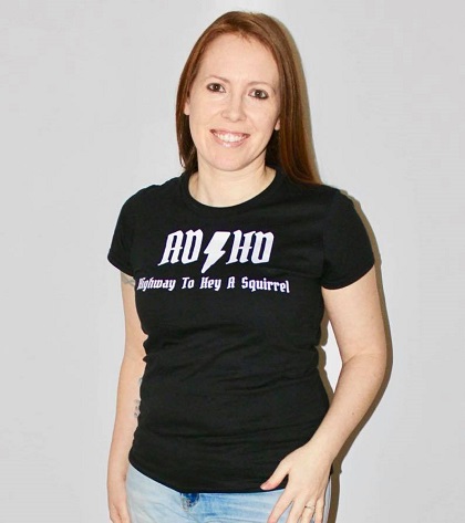 femeie zambitoare care poarta un tricou negru cu un mesaj despre ADHD