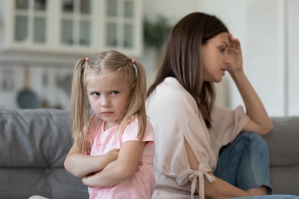 mama si fetita ei stau pe canapea, suparate una pe alta