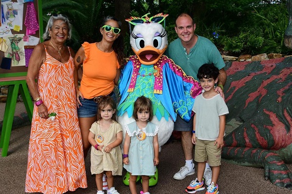 bunica, mama, tata si cei trei copii ai lor fericiti in excursie la Disney World