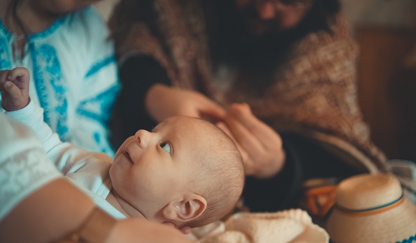bebelus vesel in timpul unei etape din cadrul unui botez ortodox