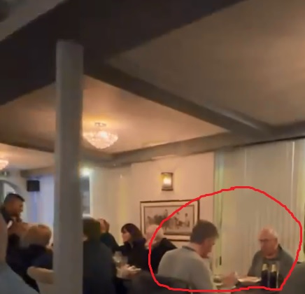 imagine dintr-un restaurant, focus pe un barbat in varsta ce ia masa cu un barbat tanar