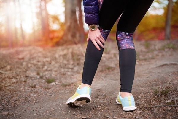 femeie imbracata in tinuta pentru alergare care se confrunta cu dureri in zona din spatele unei gambe