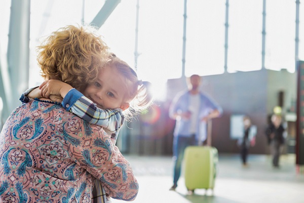 fetita care isi imbratiseaza mama in aeroport