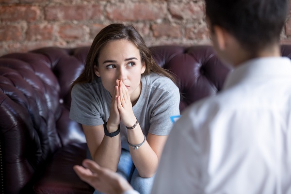 femeie tanara, trista, in timpul unei sedinte de consiliere psihologica