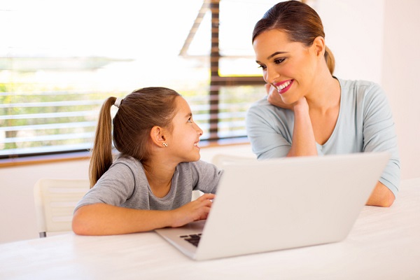 mama care discuta cu fetita ei in fata laptopului